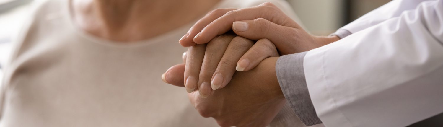 Female,Doctor,In,White,Coat,Holding,Hand,Of,Senior,Patient,